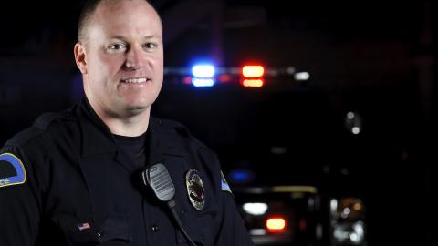 A police officer standing in front of his patrol vehicle.