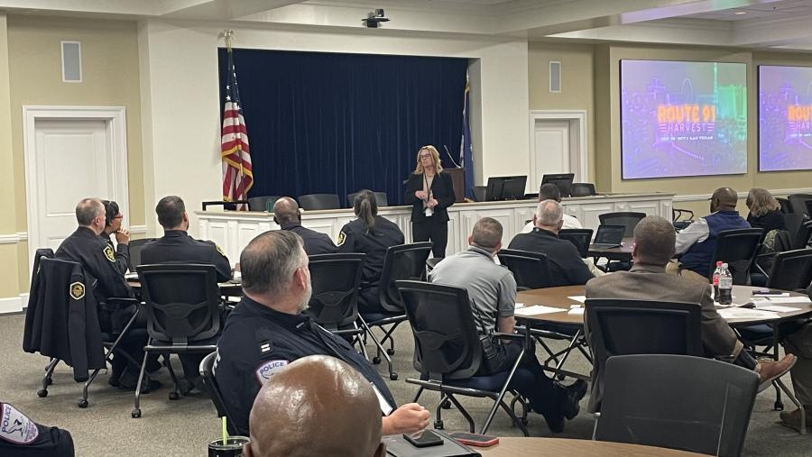 A group of people sitting and listening to a speaker at the front of the room.